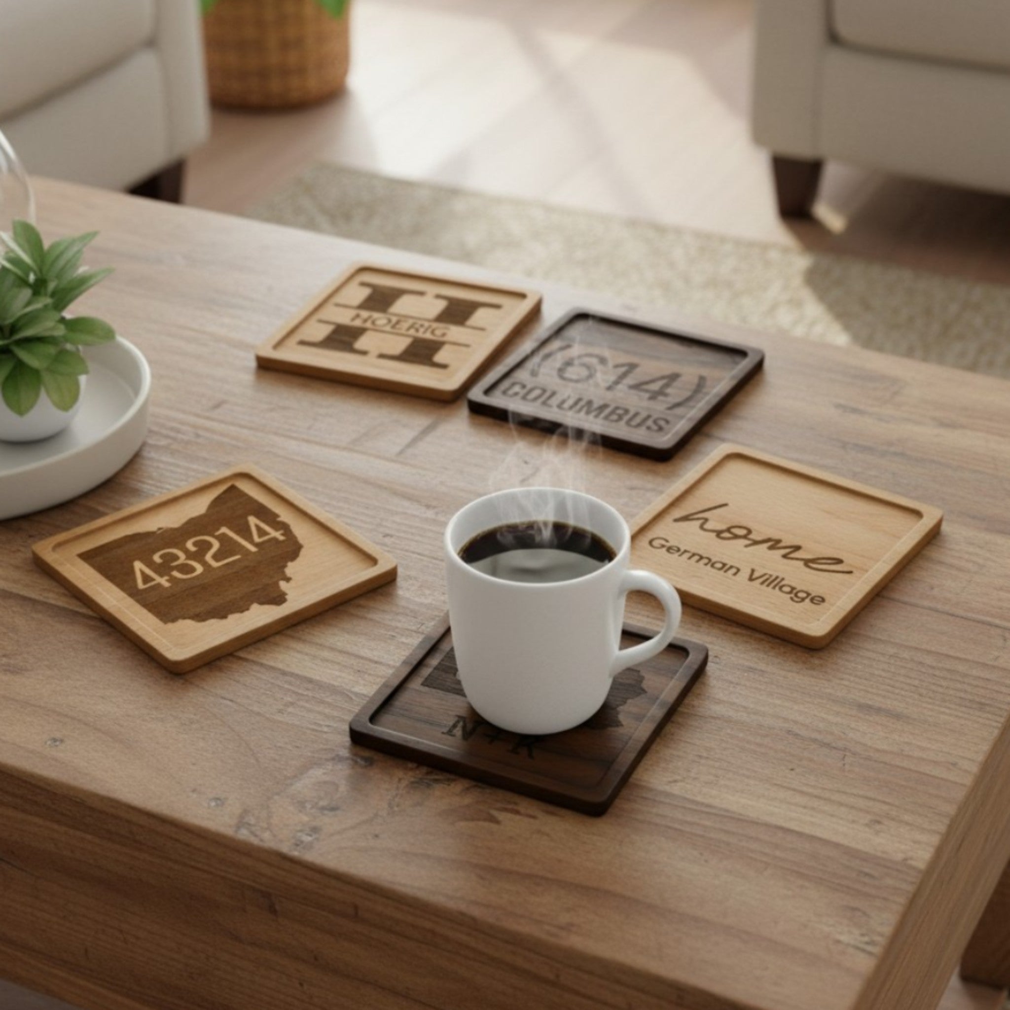 A coffee table with five personalized laser engraved coasters made from beech and black walnut. The coasters feature states, locations, and names.