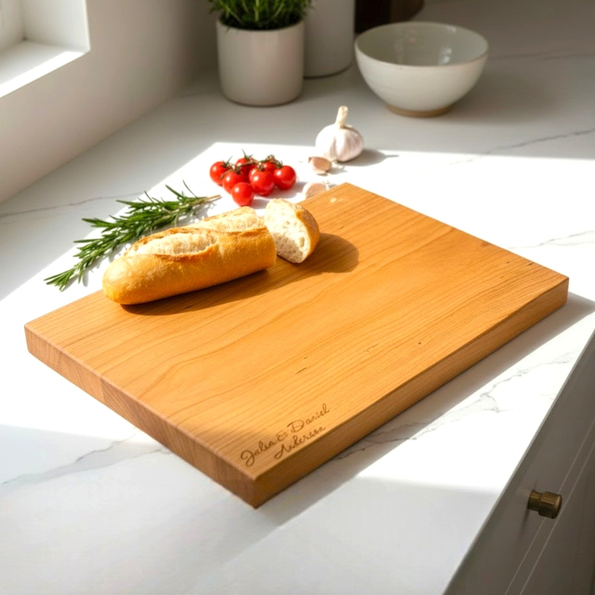 Cherry wooden cutting board with personalized engraving on a kitchen counter.