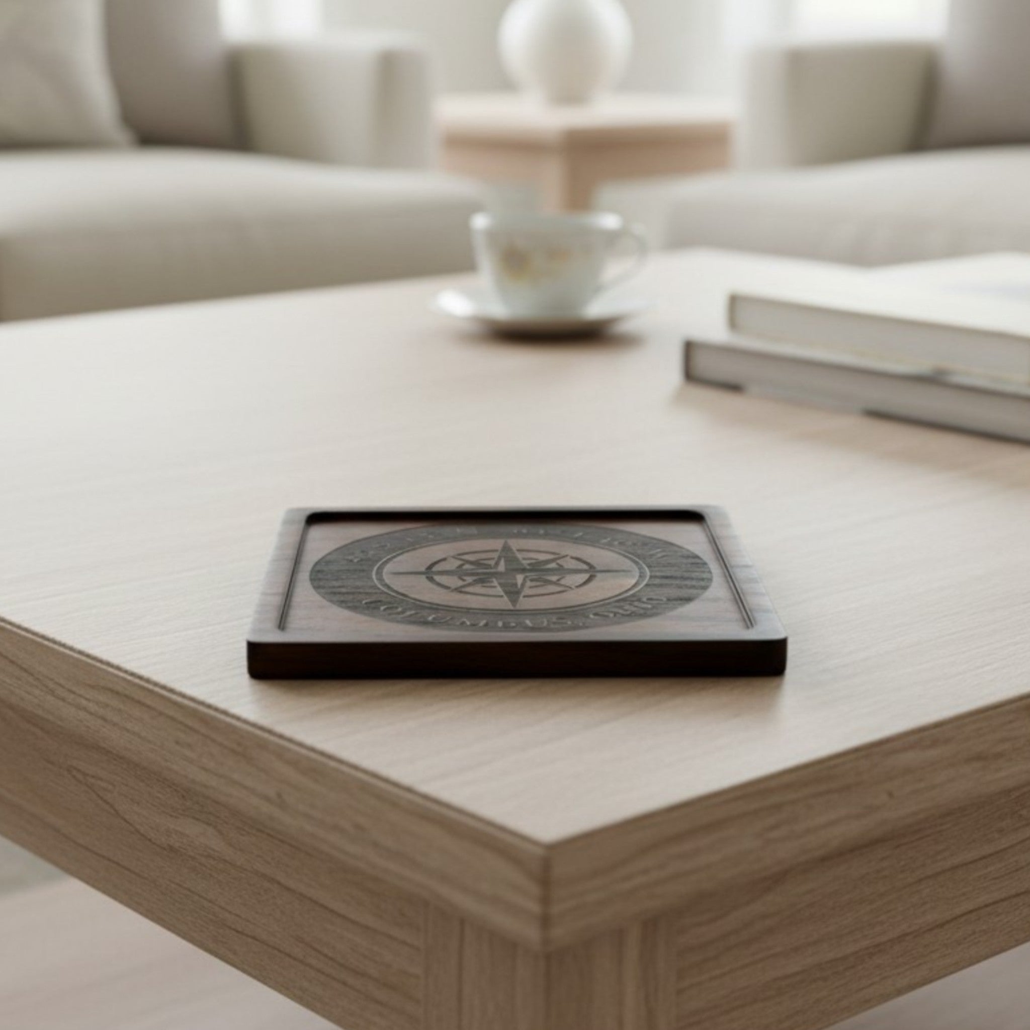Wooden coaster made of black walnut featuring a personalized laser engraved design, sitting on a table.