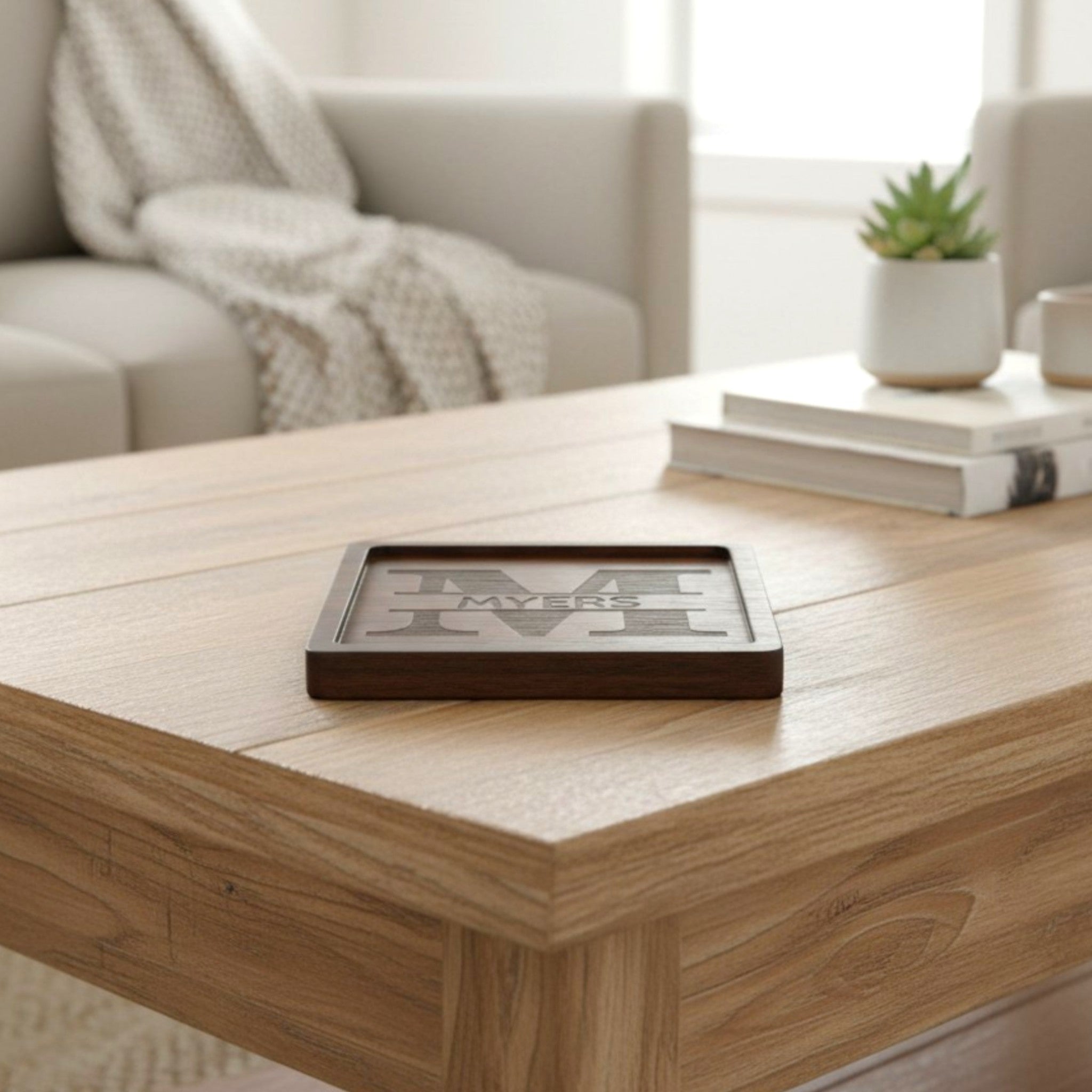 Wooden coaster made of black walnut featuring a personalized laser engraved design, sitting on a table.