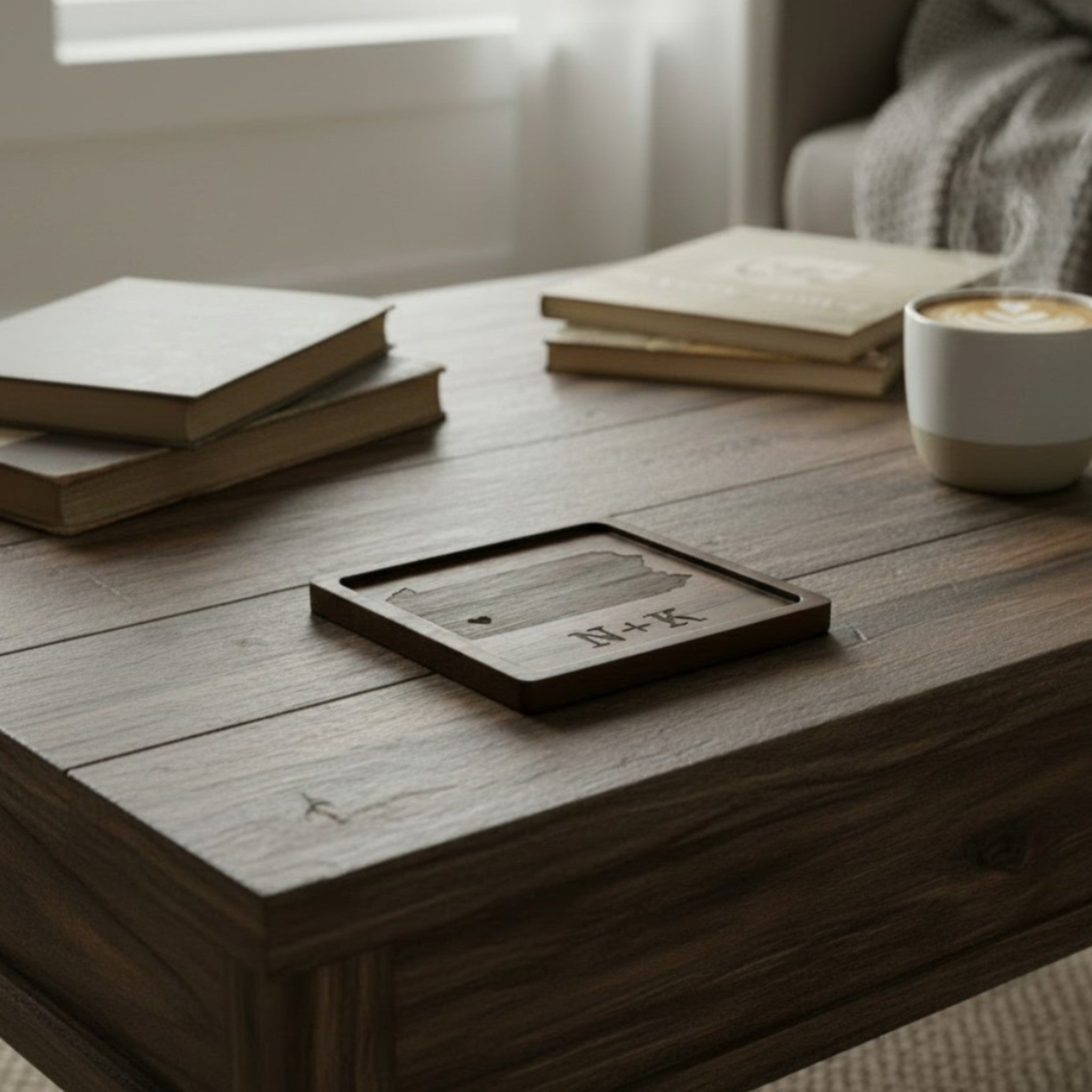 Wooden coaster made of black walnut featuring a personalized laser engraved design, sitting on a table.